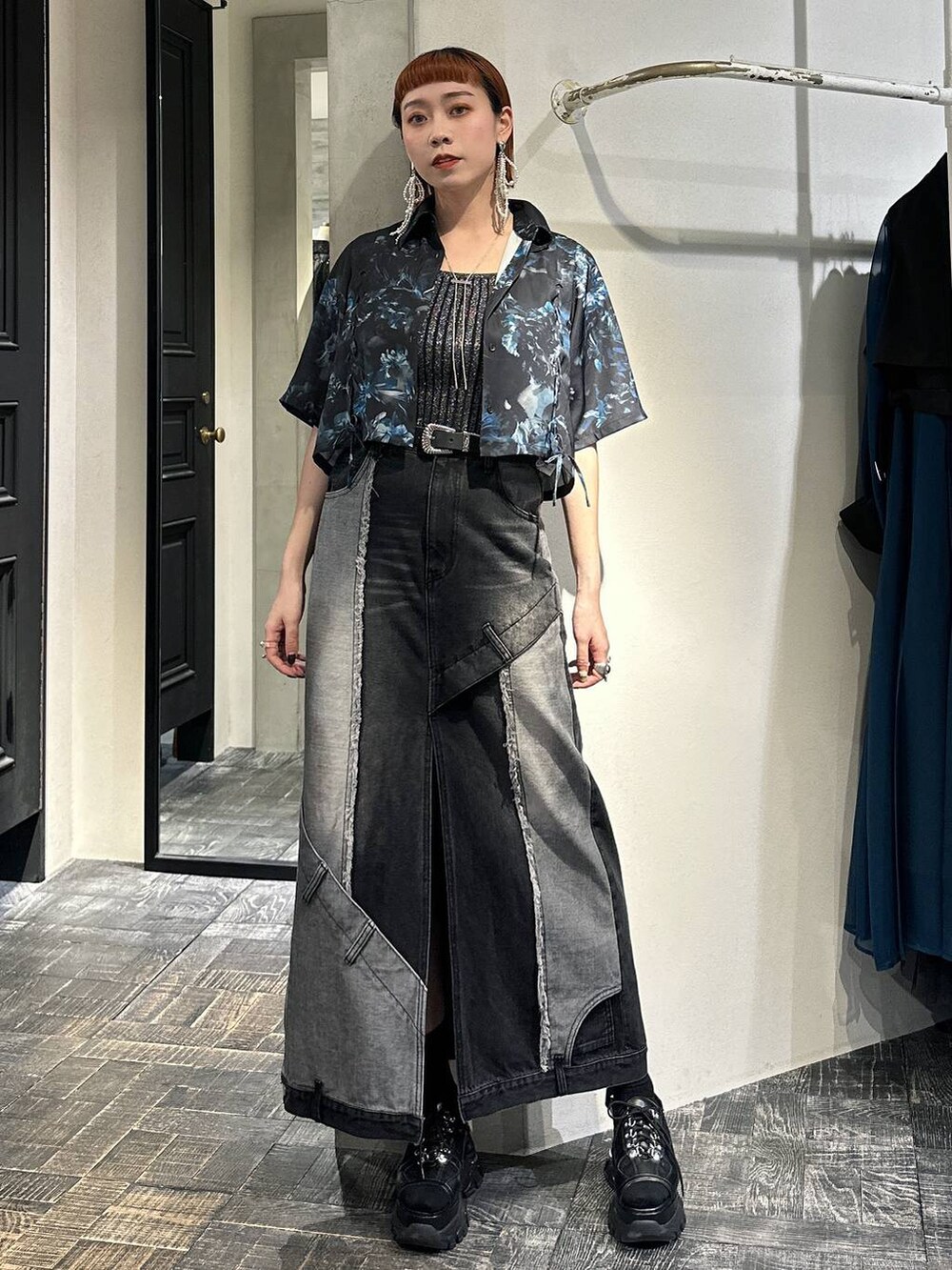 ブラック系のタンクトップ、ブラック系のサンダル、ブラック系のデニムスカートを着用したレディースの春コーディネートの5枚目の写真