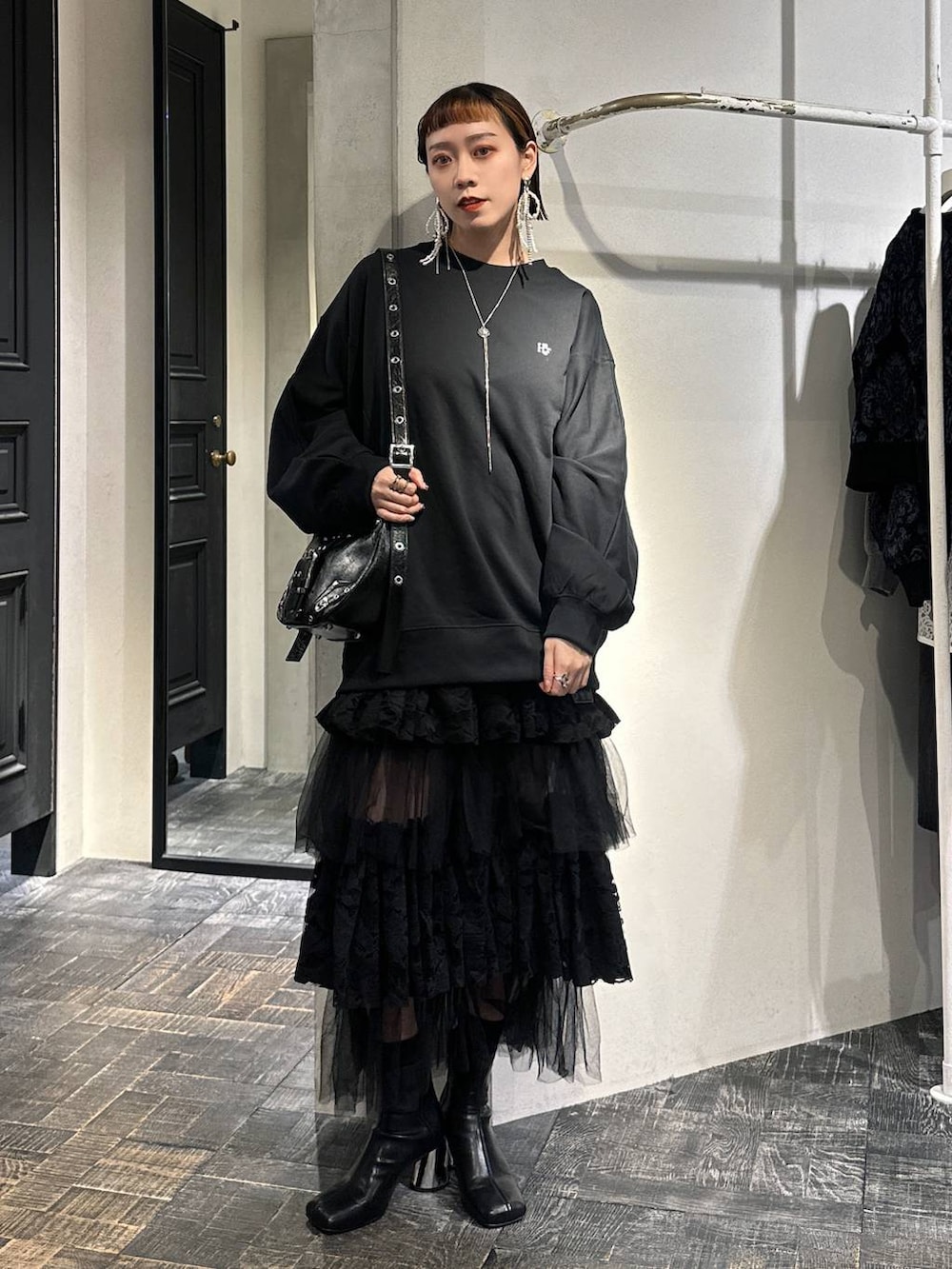 ブラック系のブーツ、ブラック系のショルダーバッグ、ブラック系のスウェットを着用したレディースの秋コーディネートの2枚目の写真