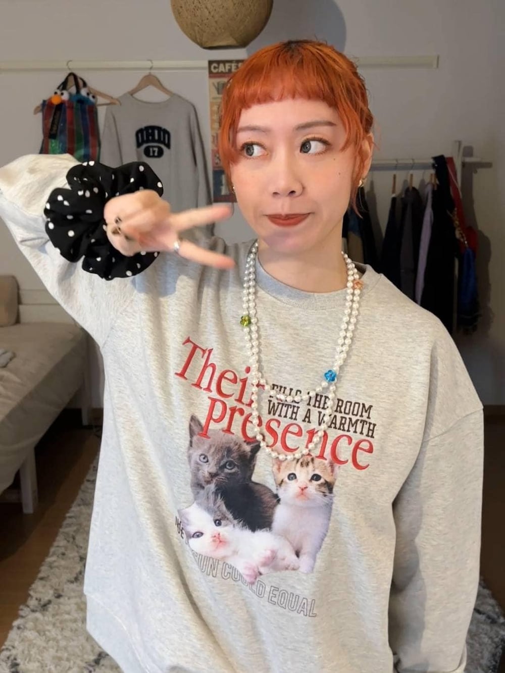 グレー系のスウェット、ホワイト系のベルト、ブラック系のシュシュを着用したレディースの冬コーディネートの4枚目の写真