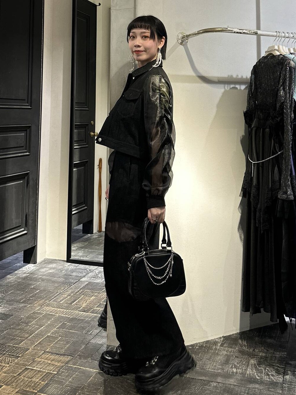 ブラック系のスニーカー、ブラック系のブルゾン、ブラック系のデニムパンツを着用したレディースの春コーディネートの4枚目の写真