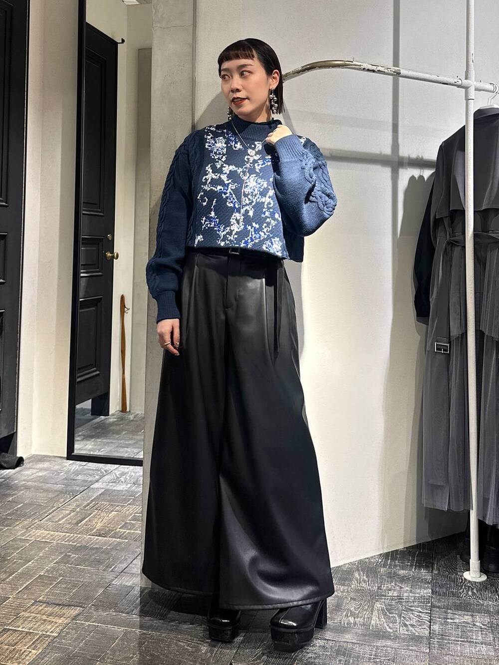 ブルー系のニット/セーター、ブラック系のその他パンツ、ブラック系のブーツを着用したレディースの冬コーディネートの7枚目の写真