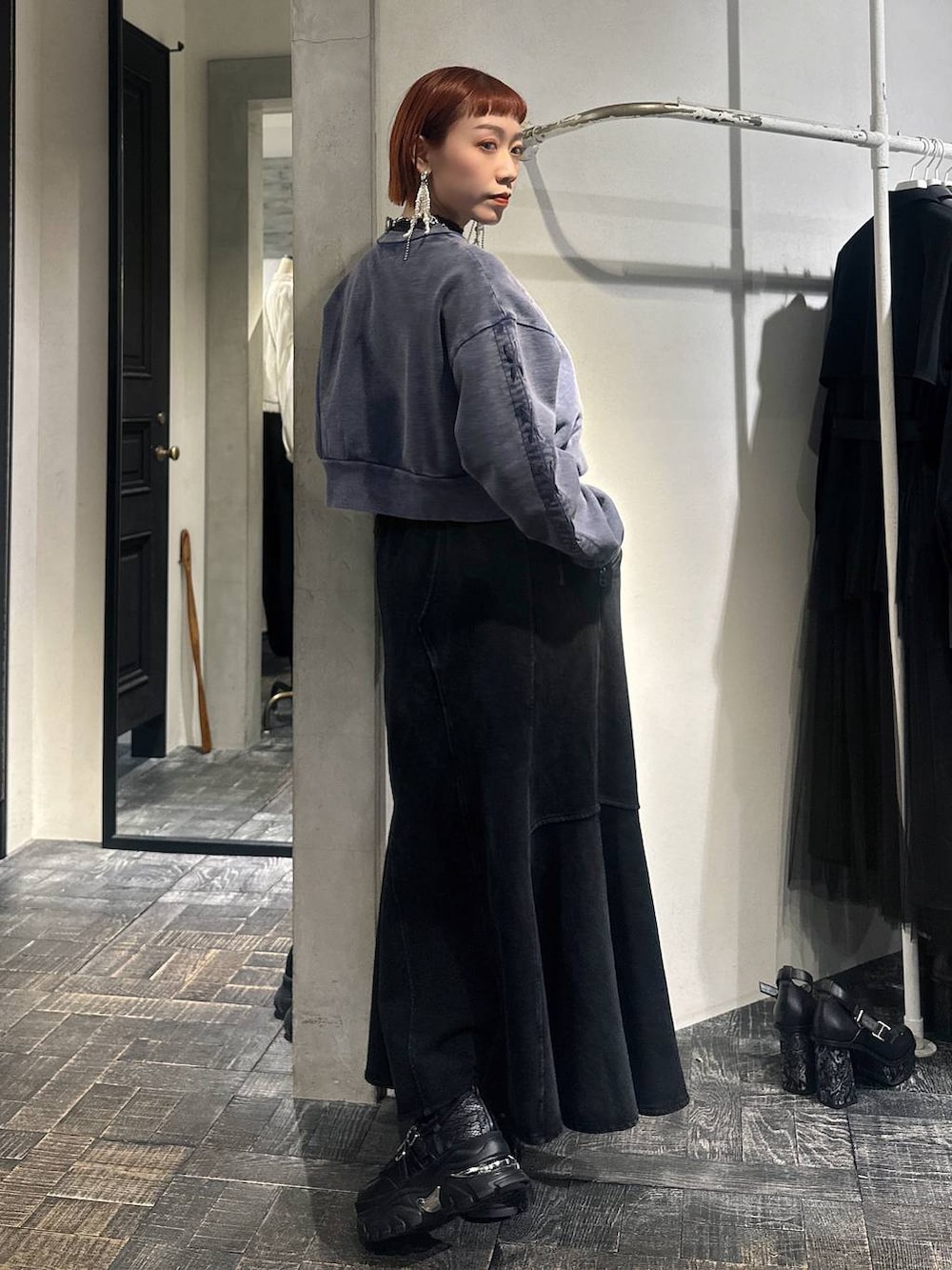 ブラック系のスカート、ブルー系のスウェット、ブラック系のスニーカーを着用したレディースの冬コーディネートの3枚目の写真