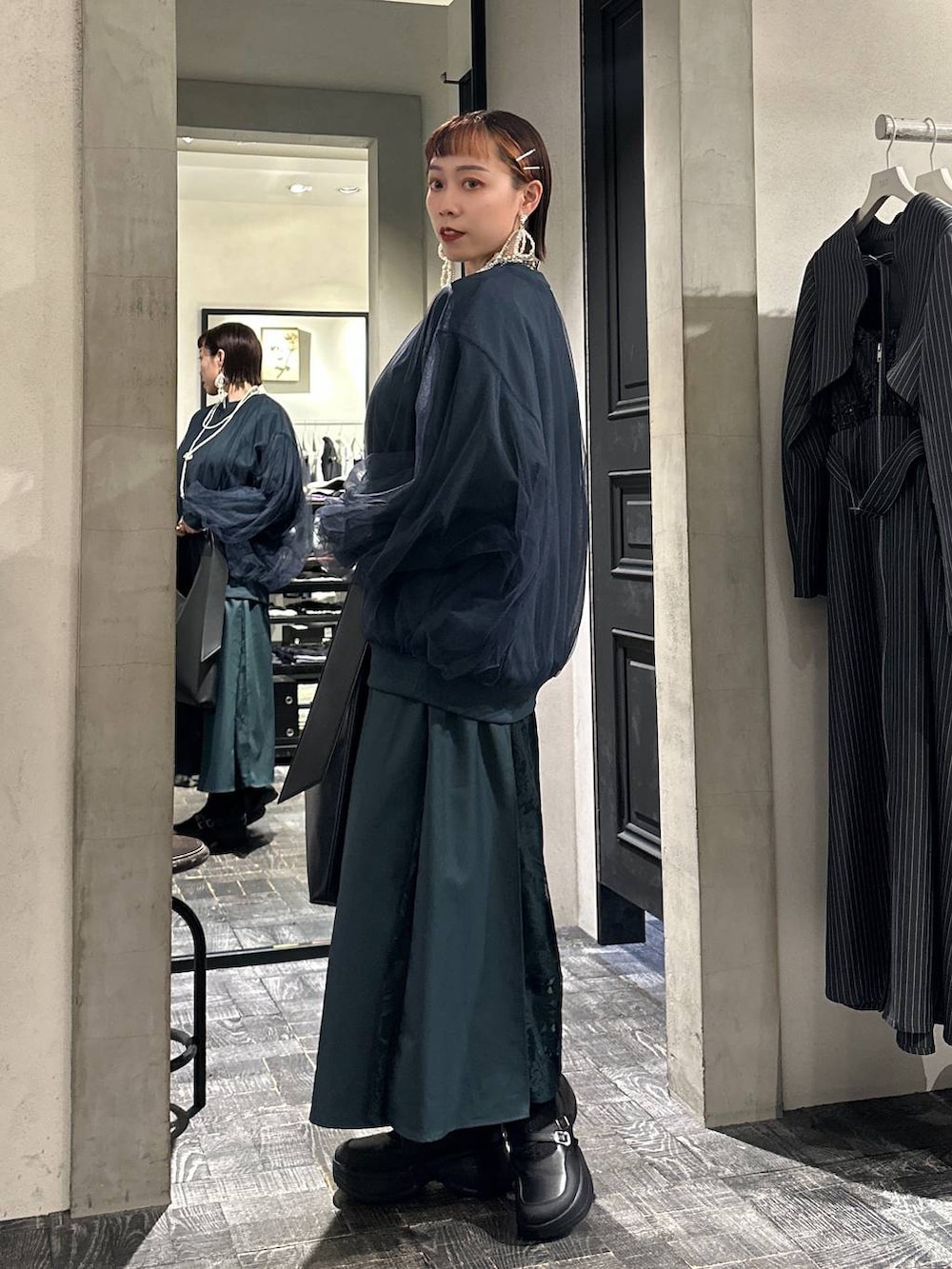 ブラック系のブーツ、ブラック系のトートバッグ、グリーン系のスウェットを着用したレディースの夏コーディネートの3枚目の写真