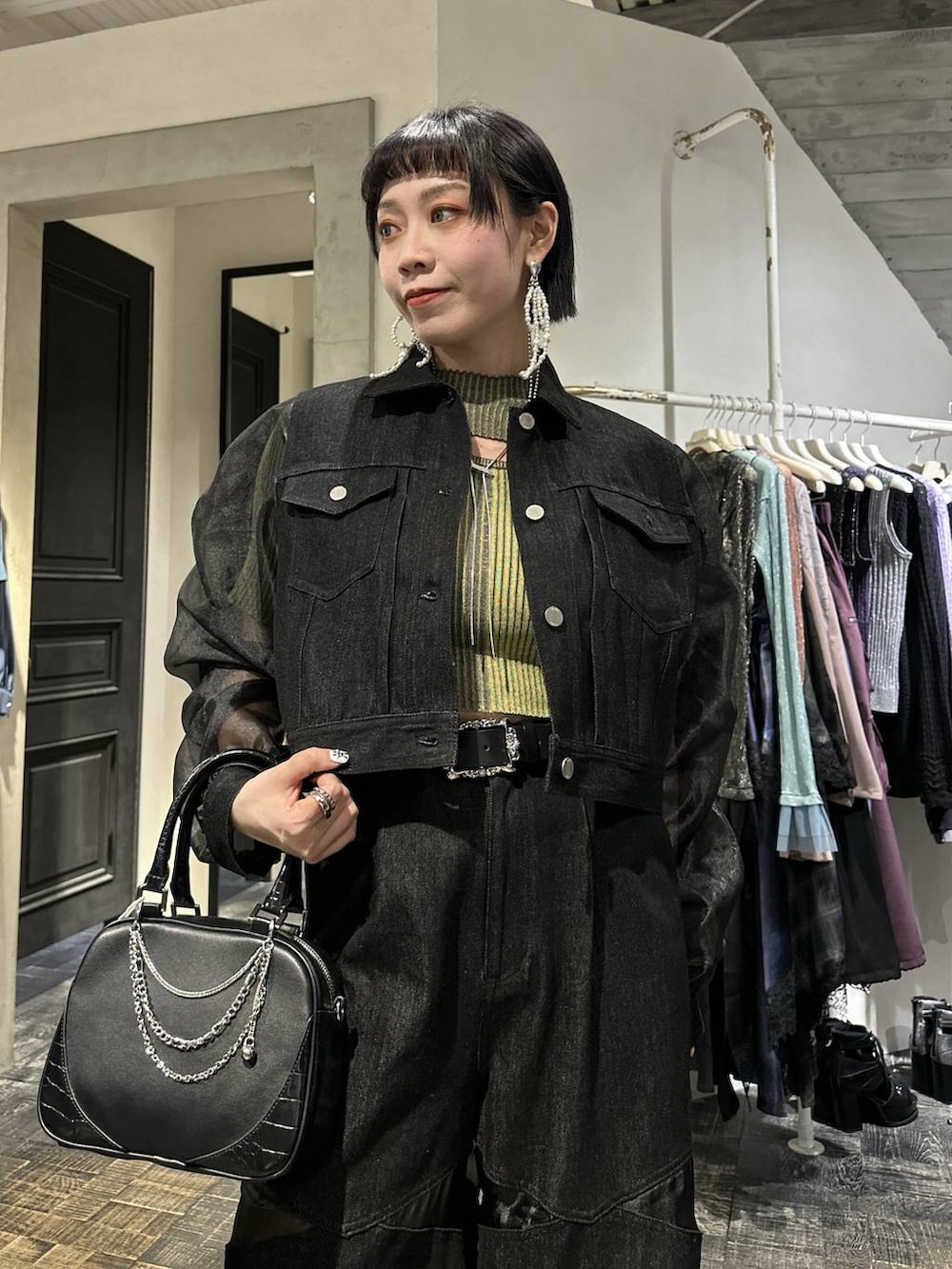 ブラック系のスニーカー、ブラック系のブルゾン、ブラック系のデニムパンツを着用したレディースの春コーディネートの2枚目の写真