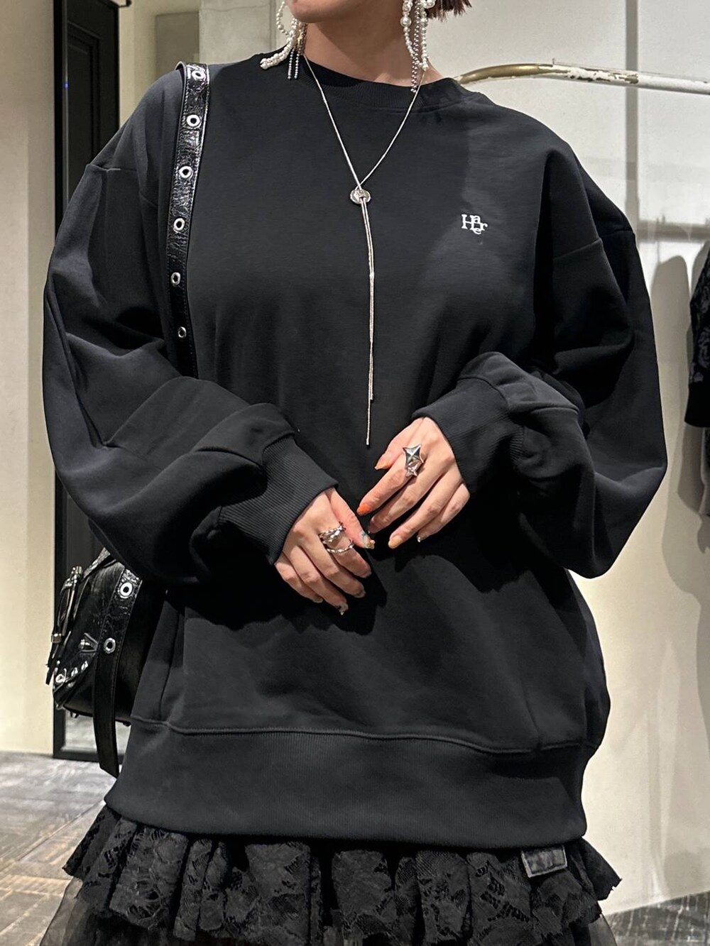 ブラック系のブーツ、ブラック系のショルダーバッグ、ブラック系のスウェットを着用したレディースの秋コーディネートの5枚目の写真