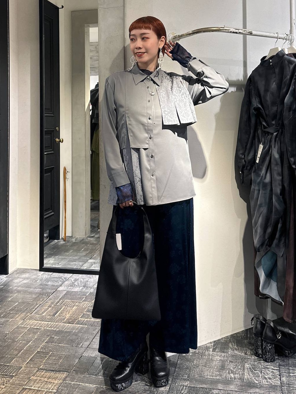 ブラック系のトートバッグ、ブルー系のTシャツ/カットソー、グレー系のシャツ/ブラウスを着用したレディースの冬コーディネートの2枚目の写真