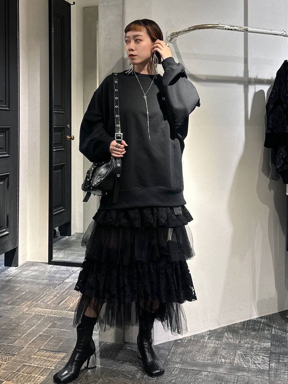 ブラック系のブーツ、ブラック系のショルダーバッグ、ブラック系のスウェットを着用したレディースの秋コーディネートの4枚目の写真