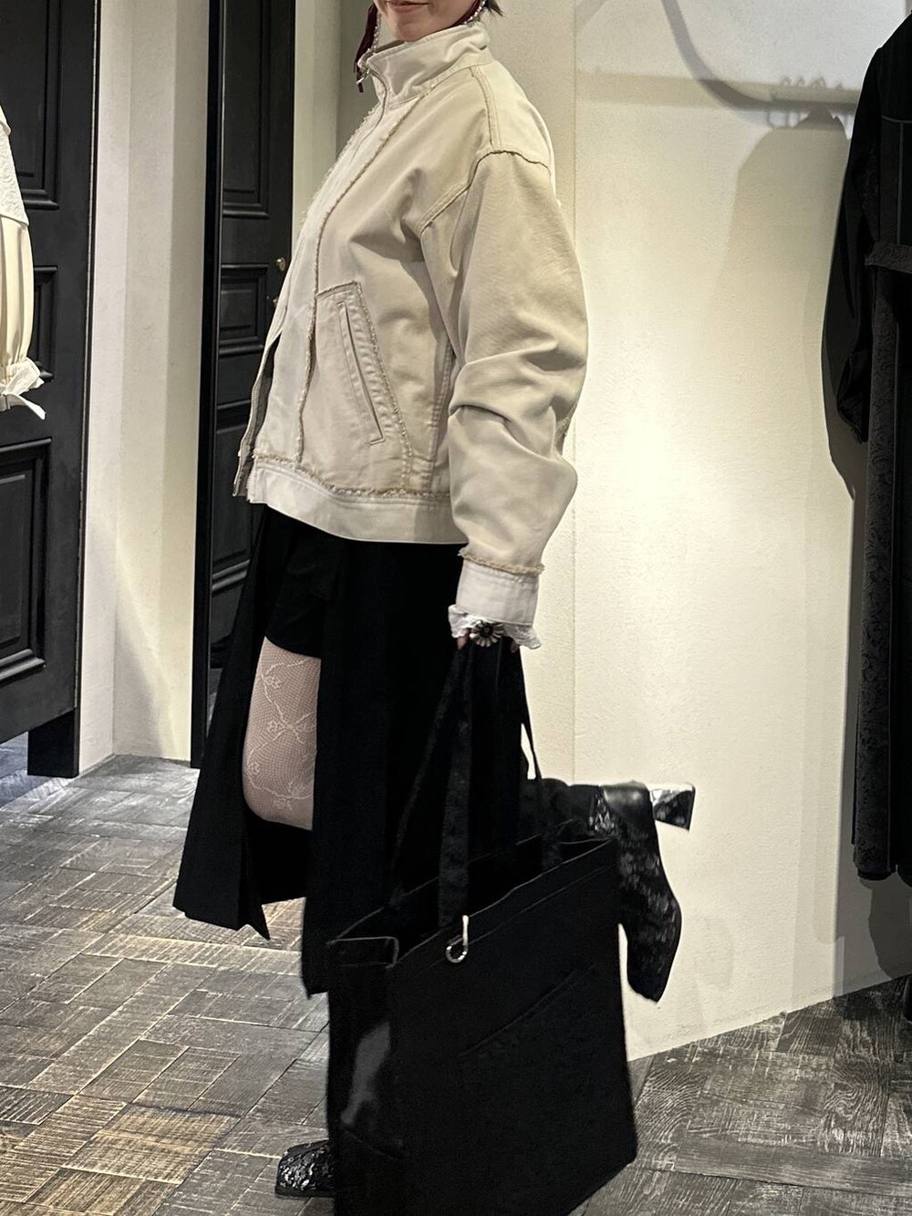 ブラック系のトートバッグ、ブラック系のブーツ、ブラック系のスカートを着用したレディースの冬コーディネートの5枚目の写真