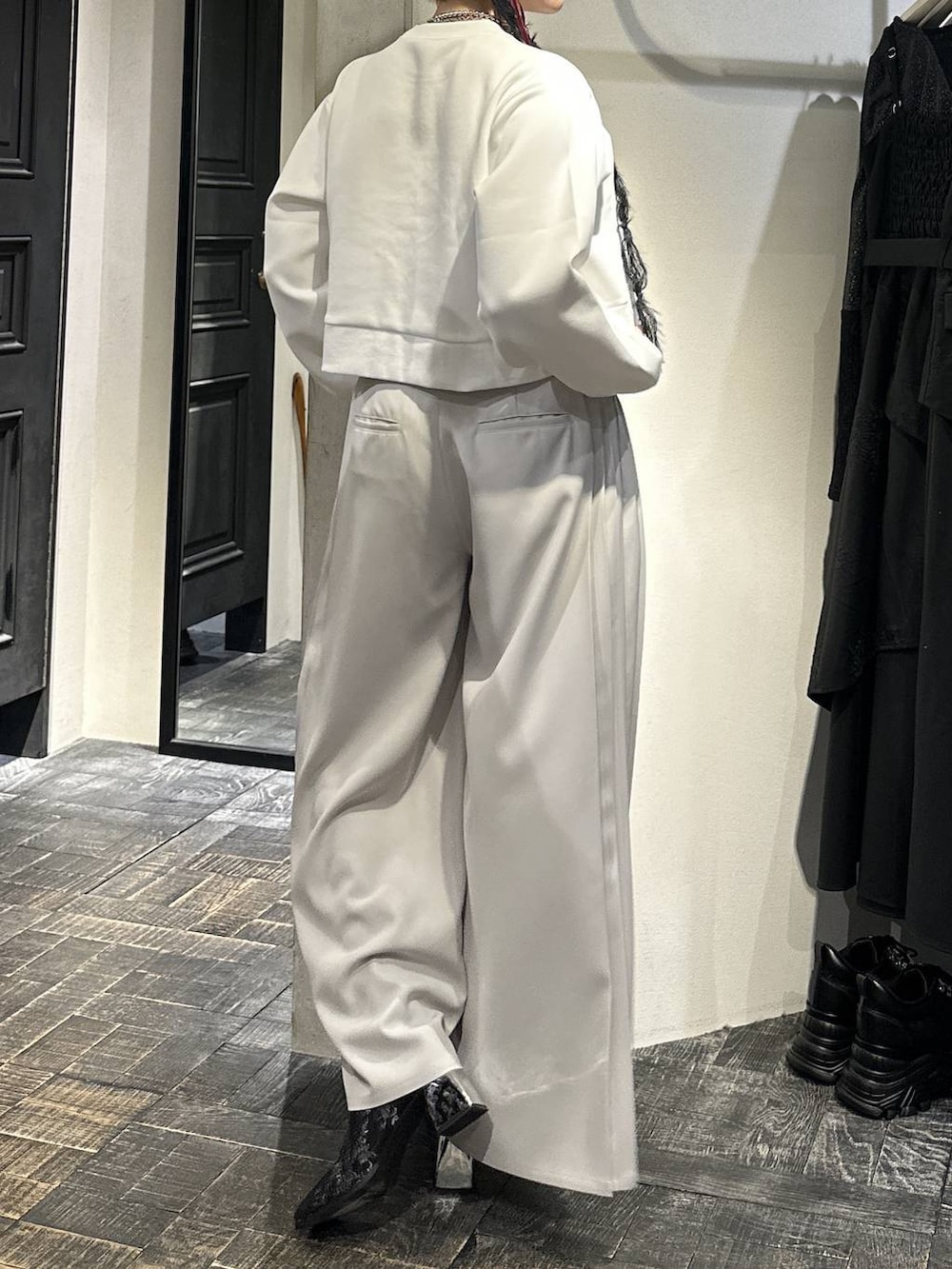 ホワイト系のスウェット、ブラック系のブーツ、ホワイト系のスラックスを着用したレディースの冬コーディネートの4枚目の写真