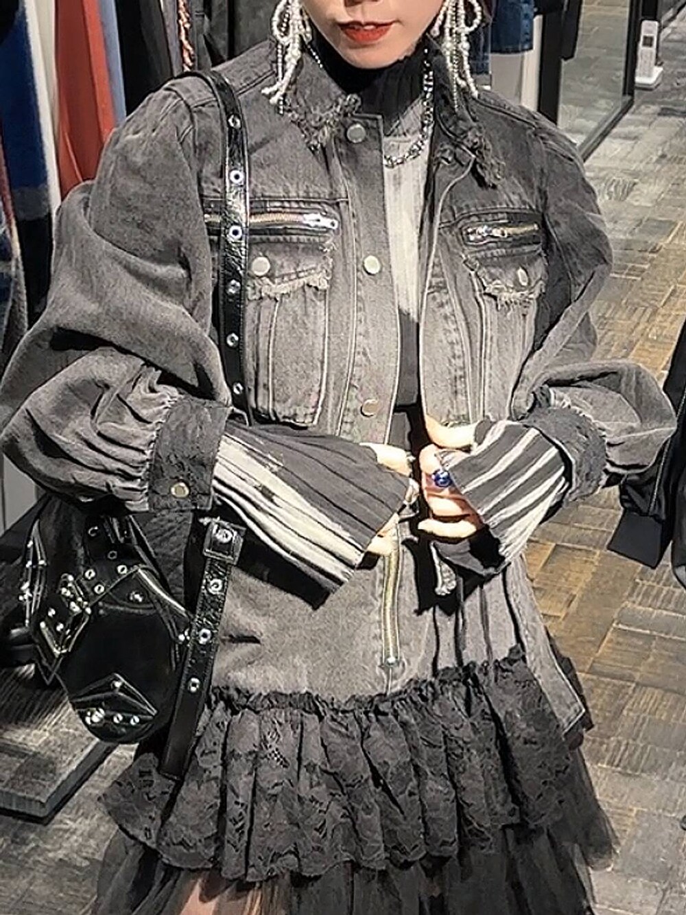 シルバー系のブーツ、ブラック系のニット/セーター、ブラック系のショルダーバッグを着用したレディースの秋コーディネートの3枚目の写真