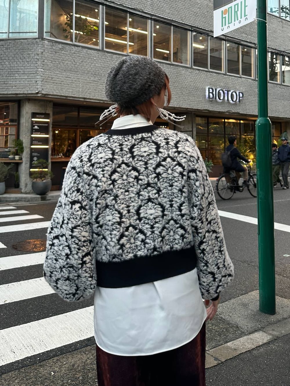 ブラック系のニット/セーター、レッド系のデニムパンツ、ホワイト系のシャツ/ブラウスを着用したレディースの秋コーディネートの5枚目の写真