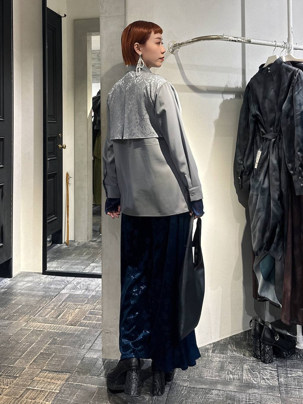 ブラック系のトートバッグ、ブルー系のTシャツ/カットソー、グレー系のシャツ/ブラウスを着用したレディースの冬コーディネートの4枚目の写真