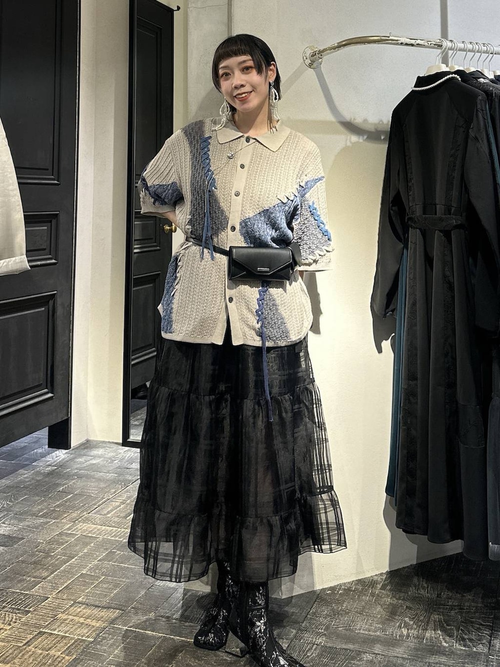 ブラック系のブーツ、ブラック系のボディバッグ/ウエストポーチ、ブラック系のスカートを着用したレディースの春コーディネートの7枚目の写真