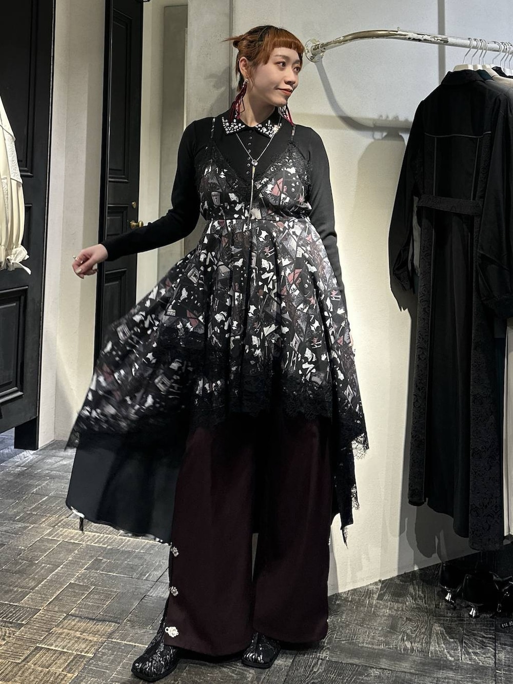 ブラック系のブーツ、ブラック系のトレンチコート、ブラック系のTシャツ/カットソーを着用したレディースの冬コーディネートの4枚目の写真