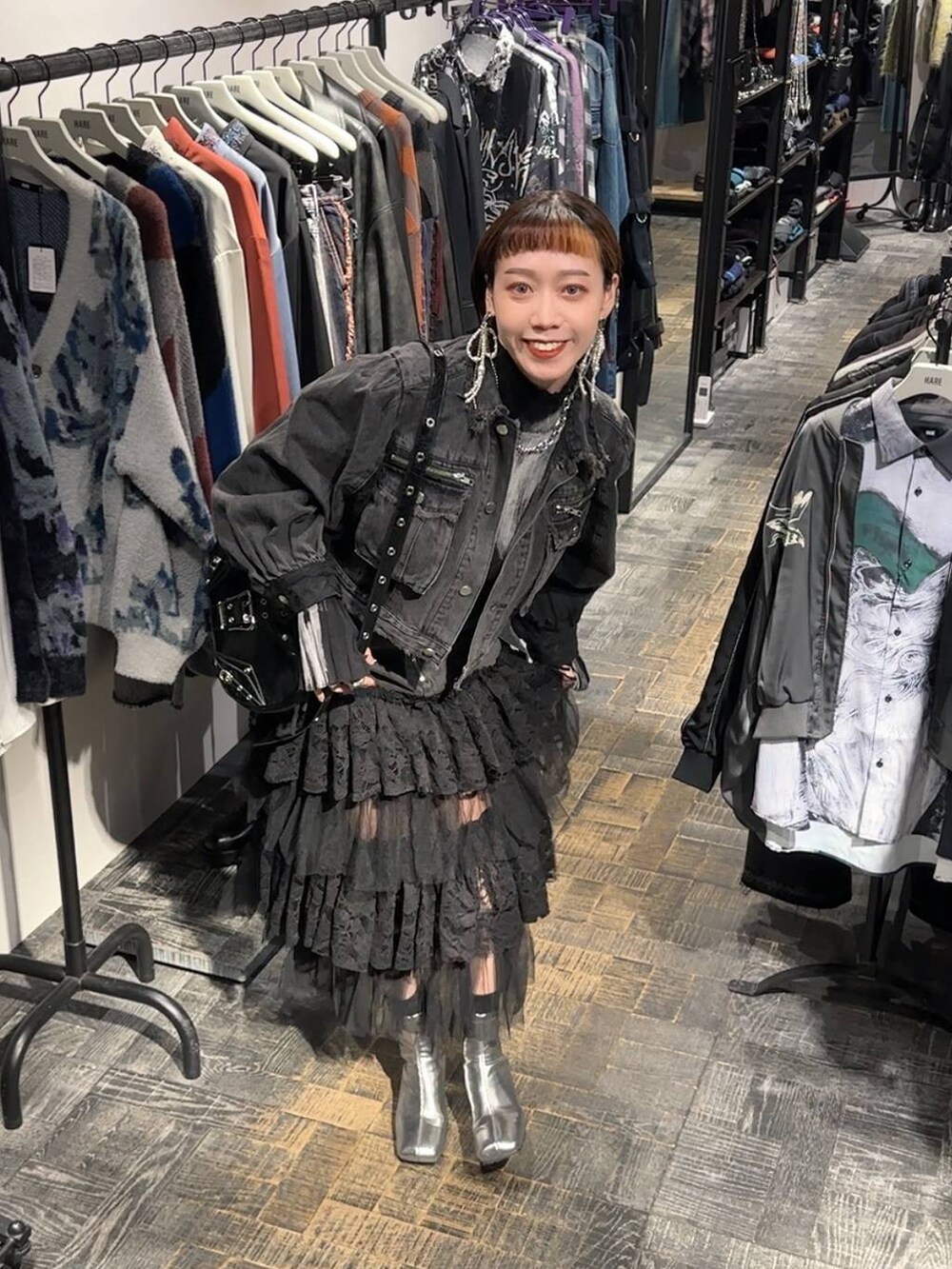 シルバー系のブーツ、ブラック系のニット/セーター、ブラック系のショルダーバッグを着用したレディースの秋コーディネートの6枚目の写真