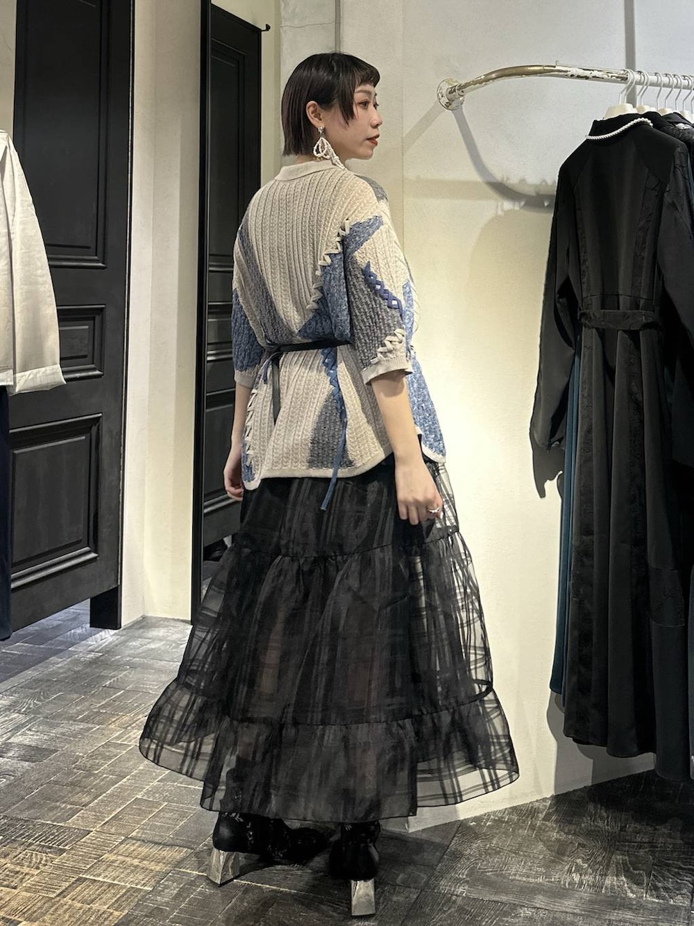 ブラック系のブーツ、ブラック系のボディバッグ/ウエストポーチ、ブラック系のスカートを着用したレディースの春コーディネートの4枚目の写真