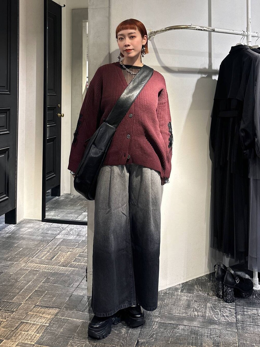 ブラック系のTシャツ/カットソー、レッド系のカーディガン/ボレロ、ブラック系のショルダーバッグを着用したレディースの冬コーディネートの2枚目の写真