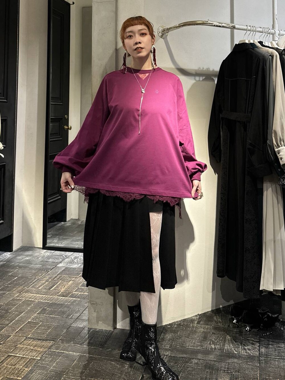 ブラック系のブーツ、ブラック系のスカート、ピンク系のTシャツ/カットソーを着用したレディースの冬コーディネートの6枚目の写真