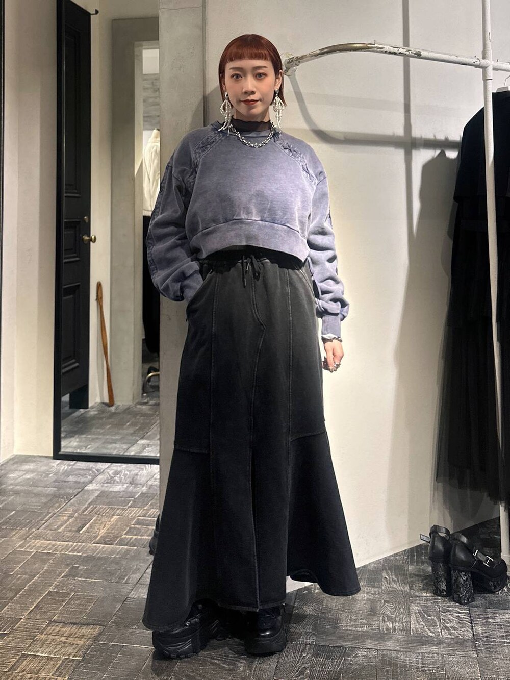 ブラック系のスカート、ブルー系のスウェット、ブラック系のスニーカーを着用したレディースの冬コーディネートの2枚目の写真