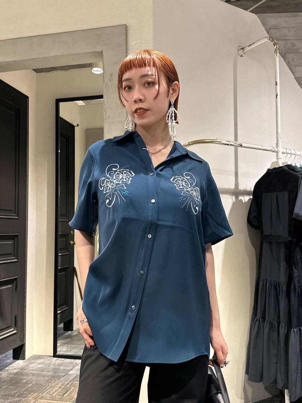 ブラック系のショルダーバッグ、ブルー系のシャツ/ブラウス、グレー系のサンダルを着用したレディースの夏コーディネートの2枚目の写真
