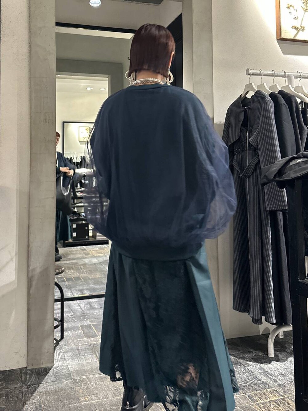 ブラック系のブーツ、ブラック系のトートバッグ、グリーン系のスウェットを着用したレディースの夏コーディネートの6枚目の写真