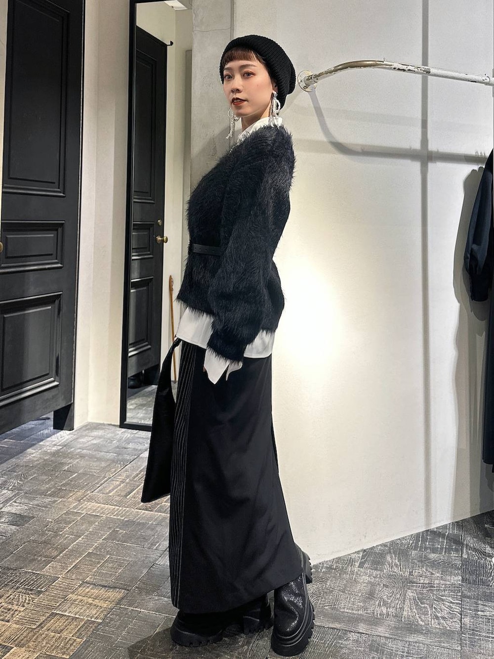 ブラック系のトートバッグ、ブラック系のカーディガン/ボレロ、ブラック系のブーツを着用したレディースの冬コーディネートの3枚目の写真