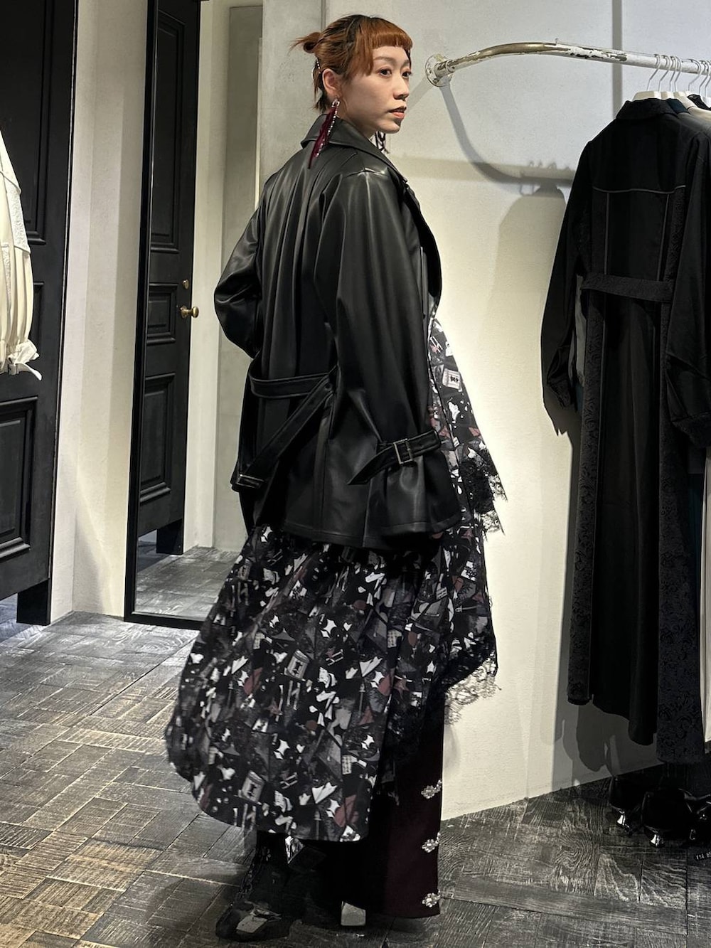 ブラック系のブーツ、ブラック系のトレンチコート、ブラック系のTシャツ/カットソーを着用したレディースの冬コーディネートの6枚目の写真