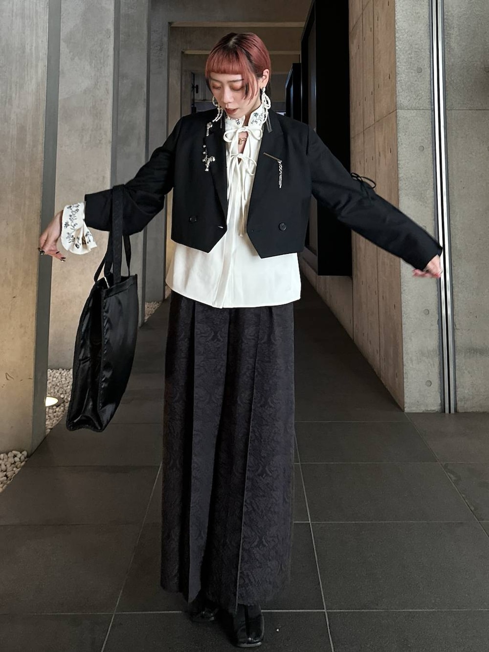 ブラック系のトートバッグ、ブラック系のブーツ、ブラウン系のその他パンツを着用したレディースの秋コーディネートの4枚目の写真