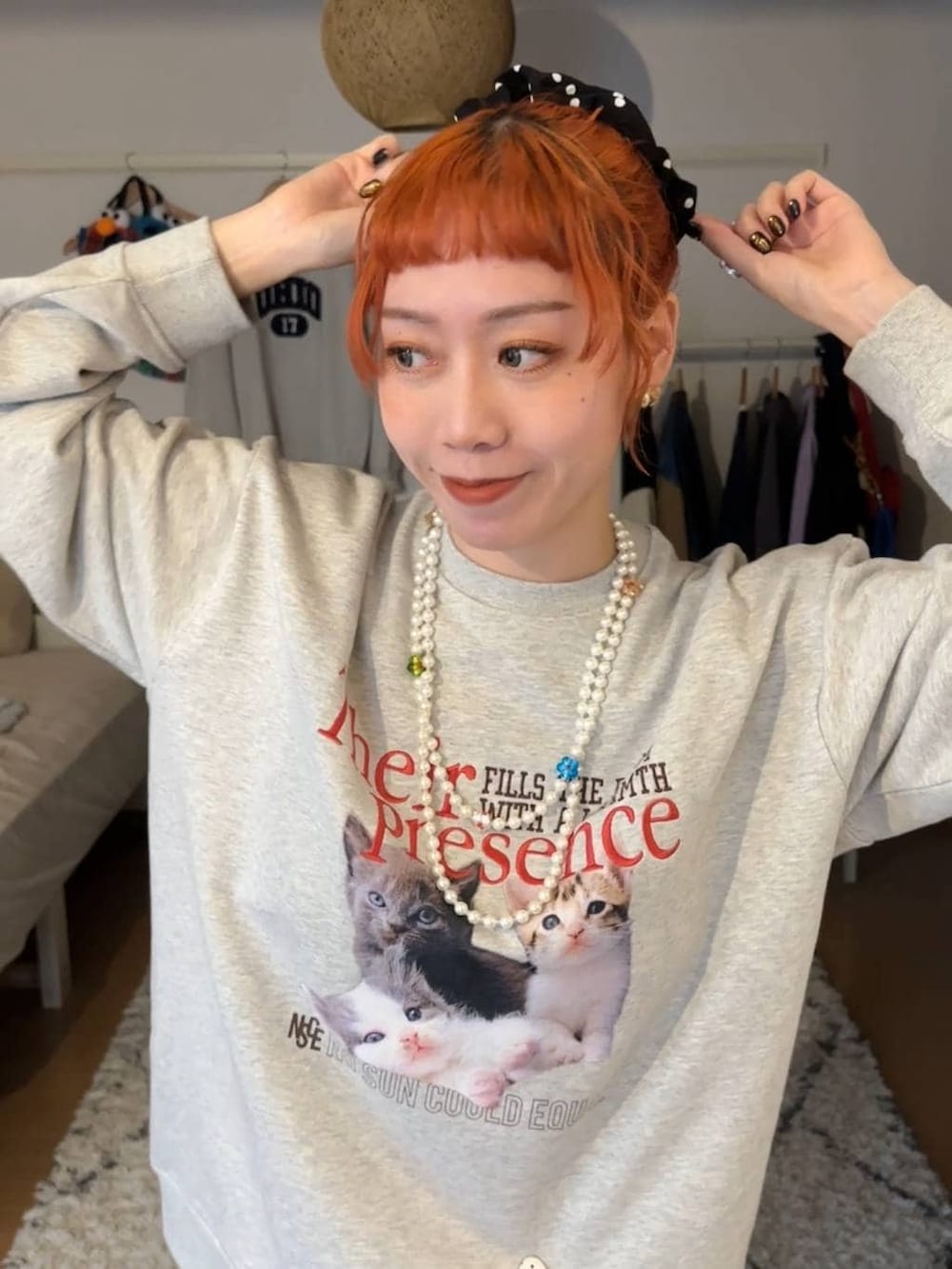 グレー系のスウェット、ホワイト系のベルト、ブラック系のシュシュを着用したレディースの冬コーディネートの3枚目の写真