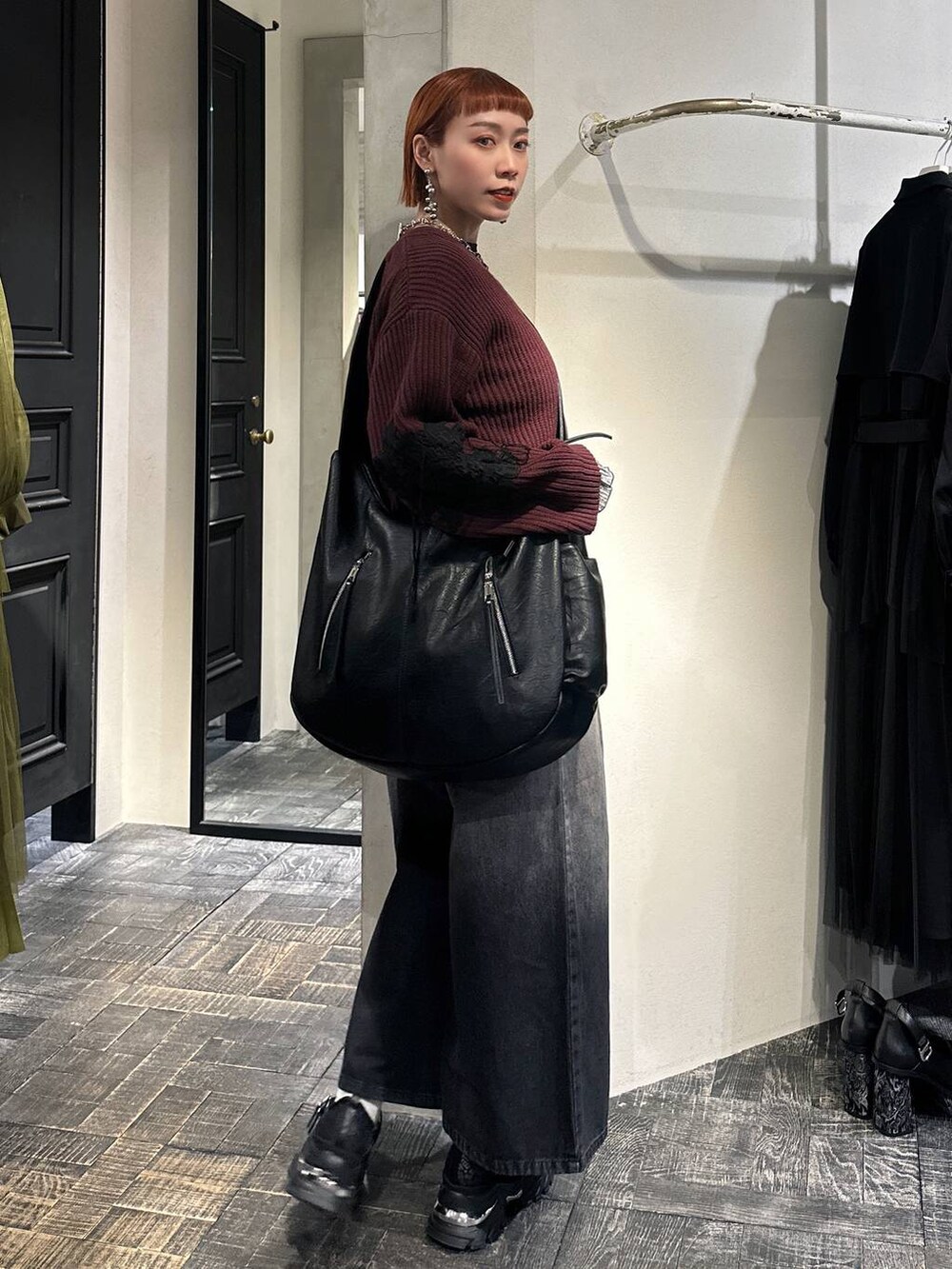ブラック系のTシャツ/カットソー、レッド系のカーディガン/ボレロ、ブラック系のショルダーバッグを着用したレディースの冬コーディネートの3枚目の写真