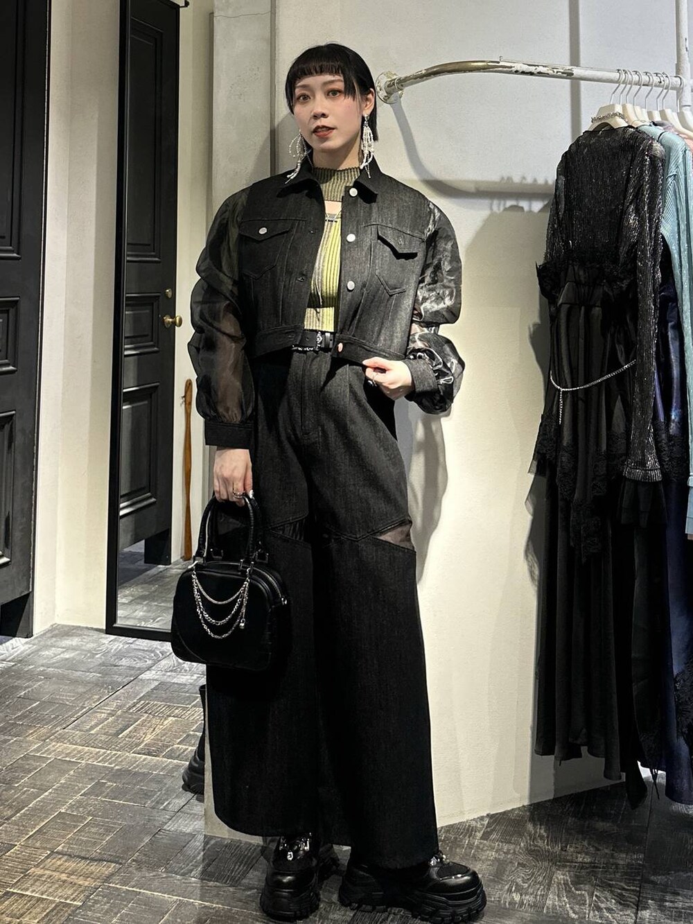 ブラック系のスニーカー、ブラック系のブルゾン、ブラック系のデニムパンツを着用したレディースの春コーディネートの6枚目の写真