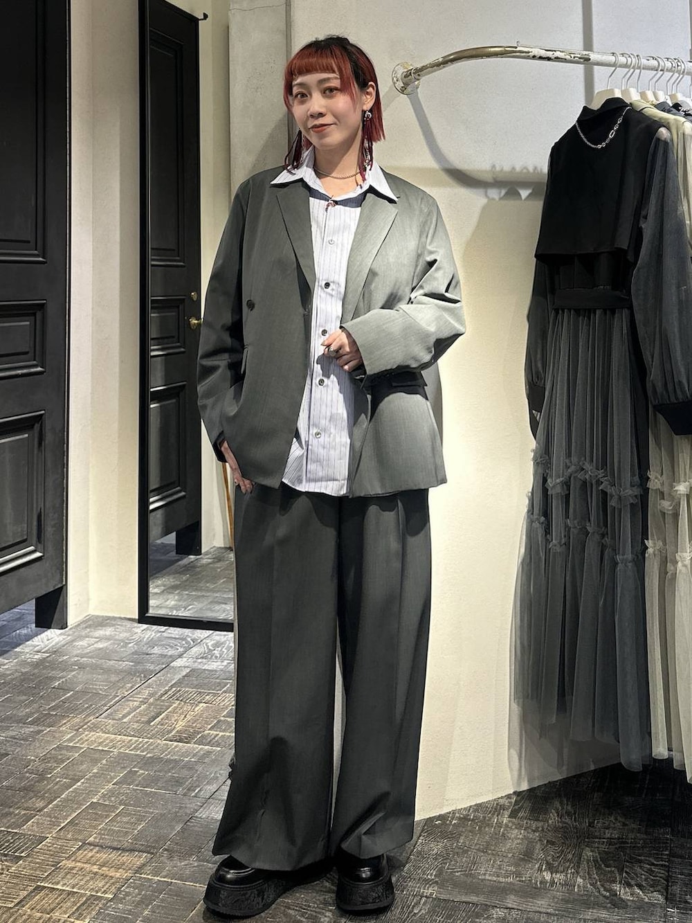 ブラック系のローファー、グレー系のスラックス、シルバー系のネックレスを着用したレディースの春コーディネートの3枚目の写真