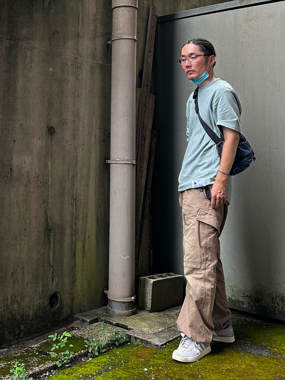 グリーン系のパンツ、ブルー系のショルダーバッグ、グリーン系のTシャツ/カットソーを着用したメンズの夏コーディネートの2枚目の写真