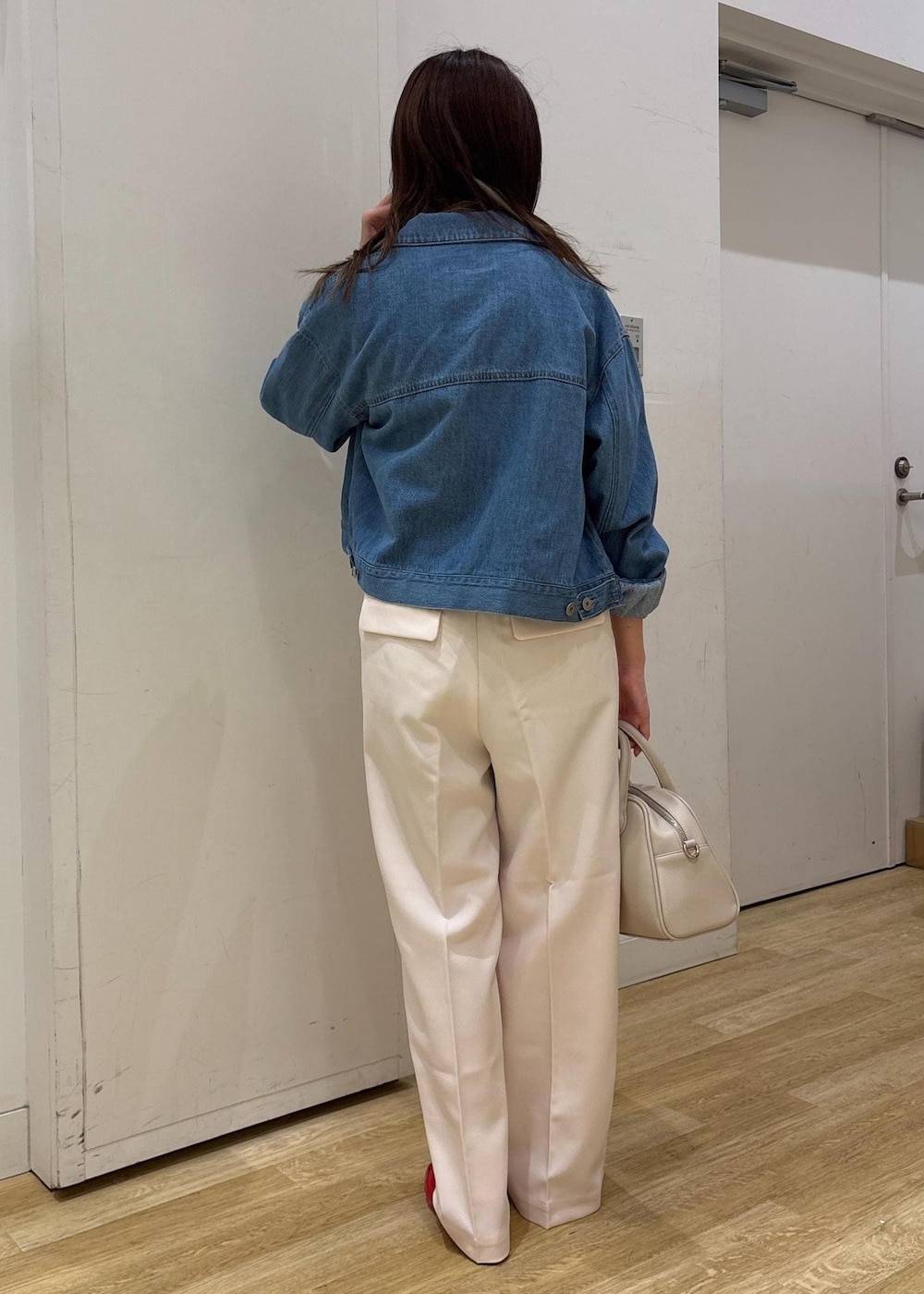 ブルー系のデニムジャケット、ブラック系のニット/セーター、ピンク系のその他パンツを着用したレディースの春コーディネートの4枚目の写真