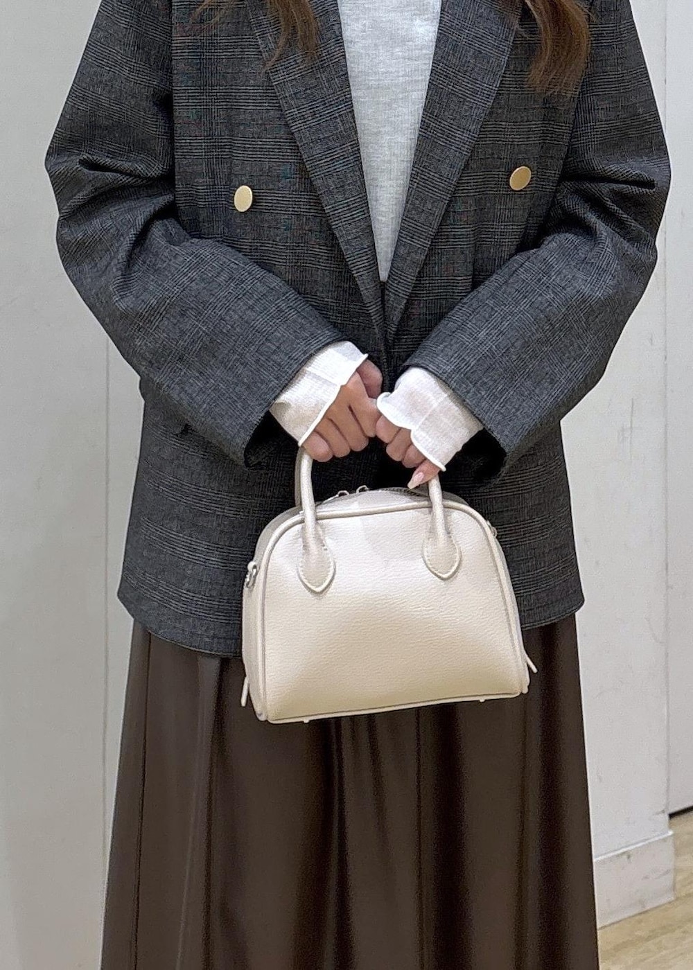 グレー系のテーラードジャケット、ホワイト系のTシャツ/カットソー、ブラウン系のスカートを着用したレディースの秋コーディネートの7枚目の写真