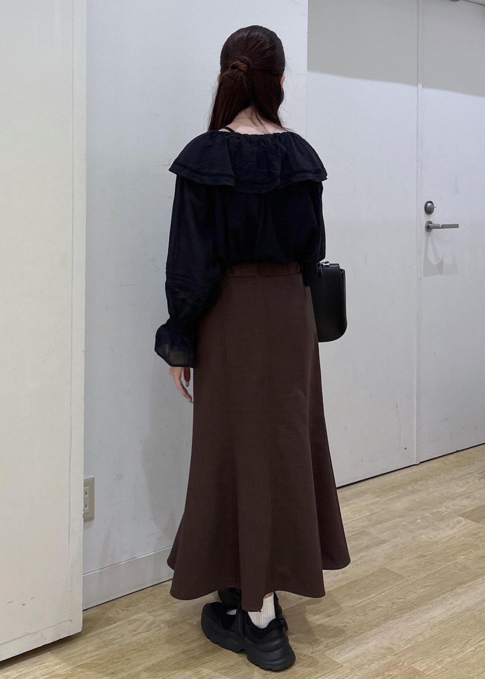 ブラック系のショルダーバッグ、ブラウン系のスカート、ブラック系のシャツ/ブラウスを着用したレディースの春コーディネートの4枚目の写真