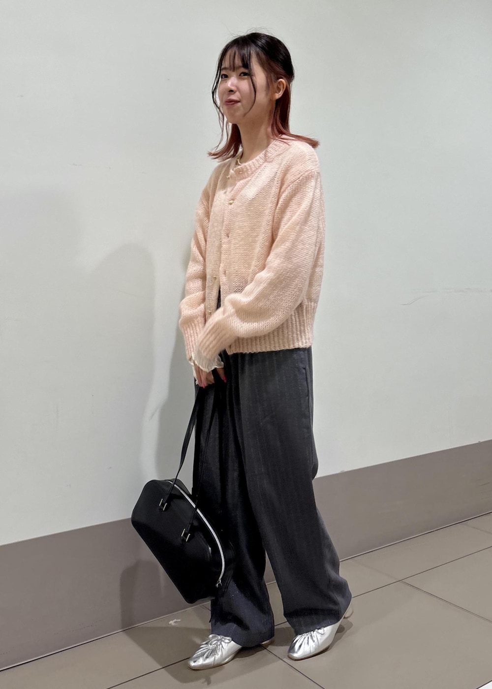 シルバー系のパンプス、ピンク系のカーディガン/ボレロ、グレー系のその他パンツを着用したレディースの冬コーディネートの3枚目の写真