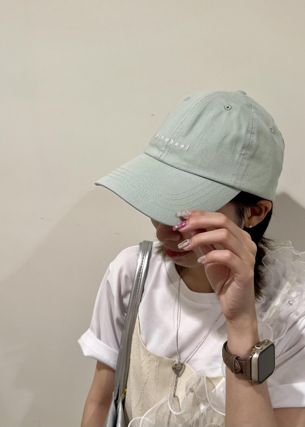 シルバー系のトートバッグ、ホワイト系のワンピース、ホワイト系のTシャツ/カットソーを着用したレディースの夏コーディネートの5枚目の写真