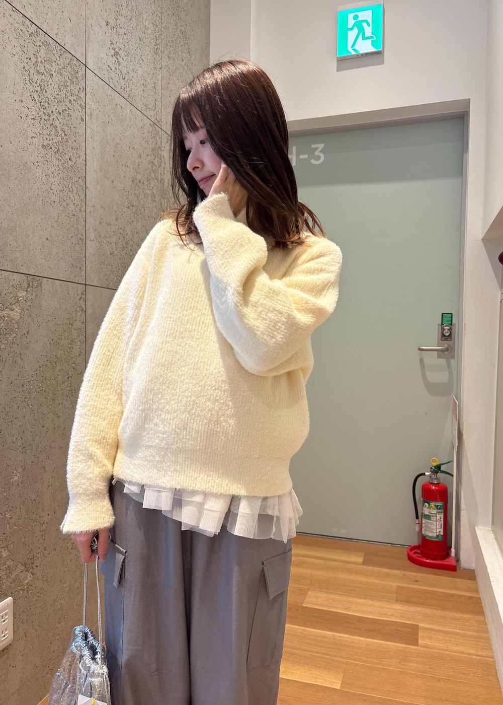 ホワイト系のベスト、シルバー系のショルダーバッグ、ホワイト系のニット/セーターを着用したレディースの春コーディネートの6枚目の写真