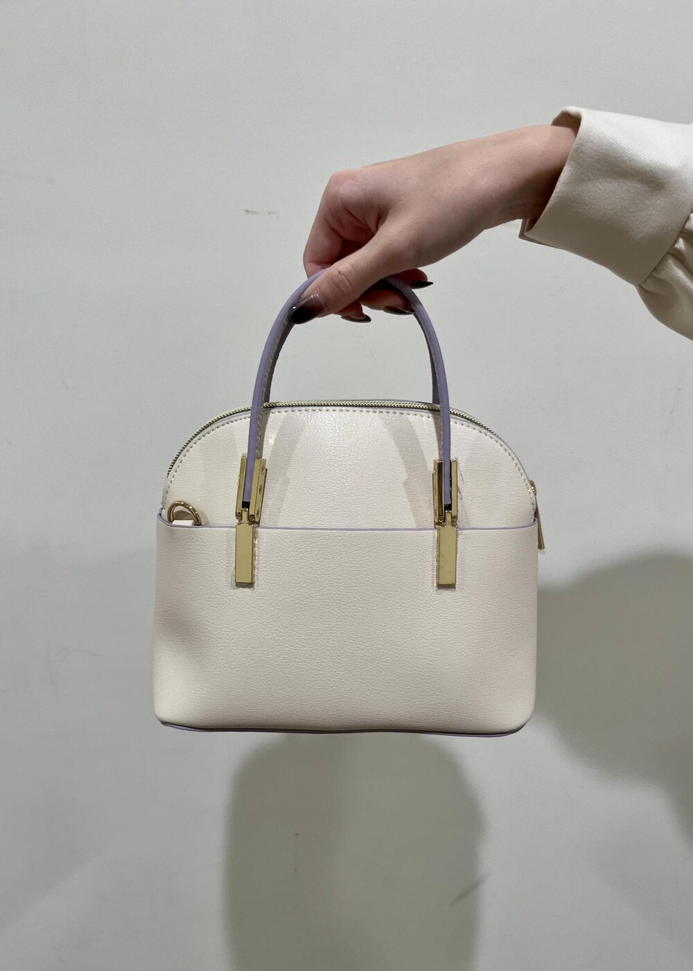 ホワイト系のショルダーバッグ、ホワイト系のパンプス、ホワイト系のシャツ/ブラウスを着用したレディースの冬コーディネートの6枚目の写真