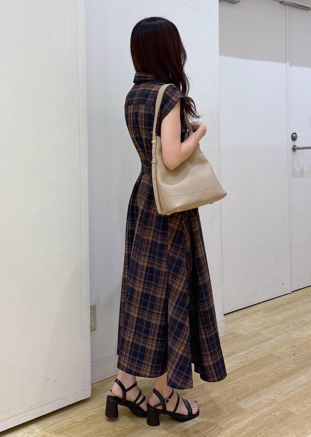 ベージュ系のショルダーバッグ、ブルー系のワンピースを着用したレディースの夏コーディネートの3枚目の写真