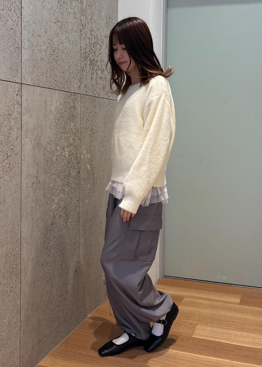 ホワイト系のベスト、シルバー系のショルダーバッグ、ホワイト系のニット/セーターを着用したレディースの春コーディネートの2枚目の写真