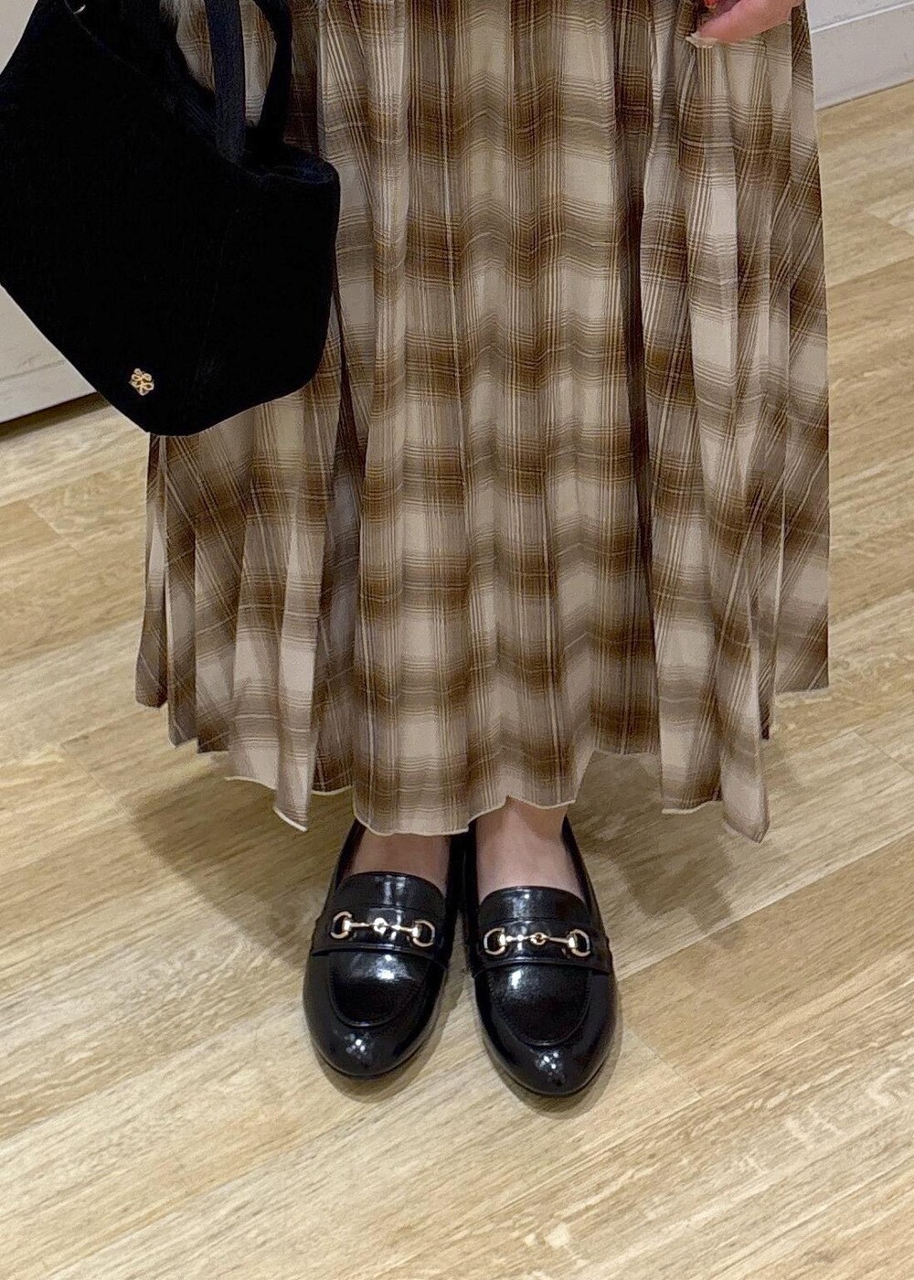 ホワイト系のタンクトップ、ホワイト系のベスト、イエロー系のスカートを着用したレディースの秋コーディネートの8枚目の写真