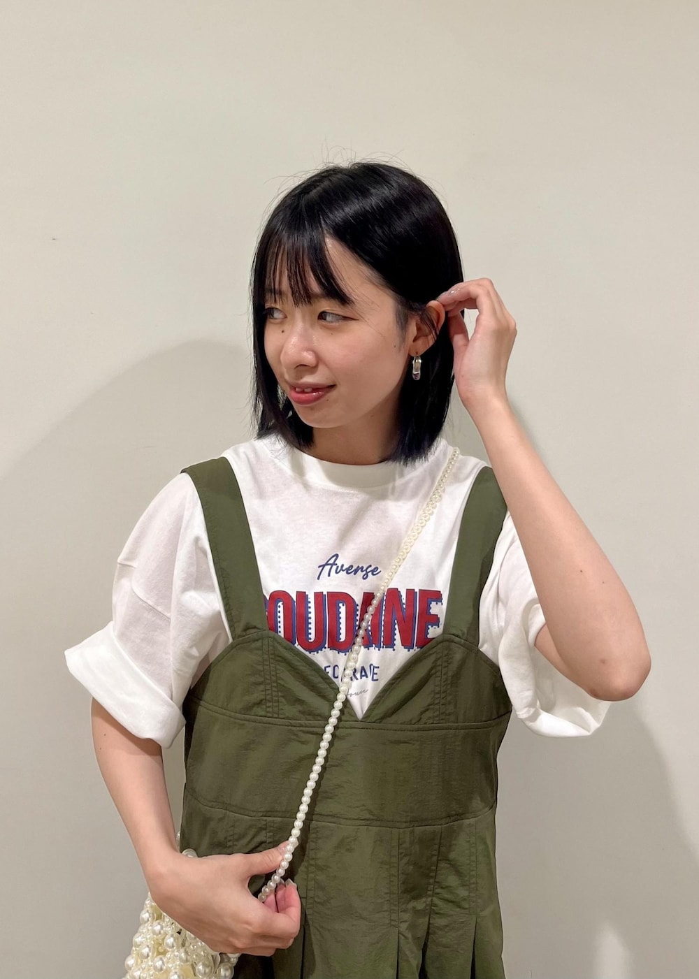 グリーン系のワンピース、ホワイト系のショルダーバッグ、ホワイト系のTシャツ/カットソーを着用したレディースの夏コーディネートの4枚目の写真