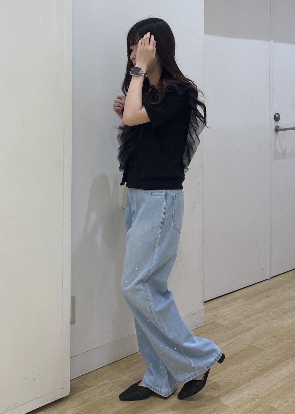 ブルー系のデニムパンツ、ブラック系のサンダル、ブラック系のハンドバッグを着用したレディースの春コーディネートの5枚目の写真