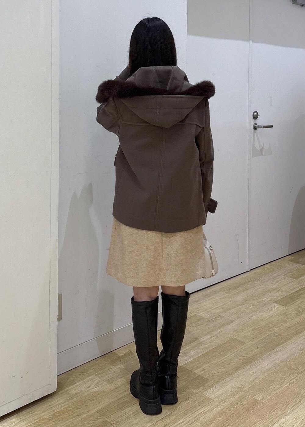 ホワイト系のニット/セーター、ベージュ系のショルダーバッグ、ブラウン系のダッフルコートを着用したレディースの冬コーディネートの3枚目の写真