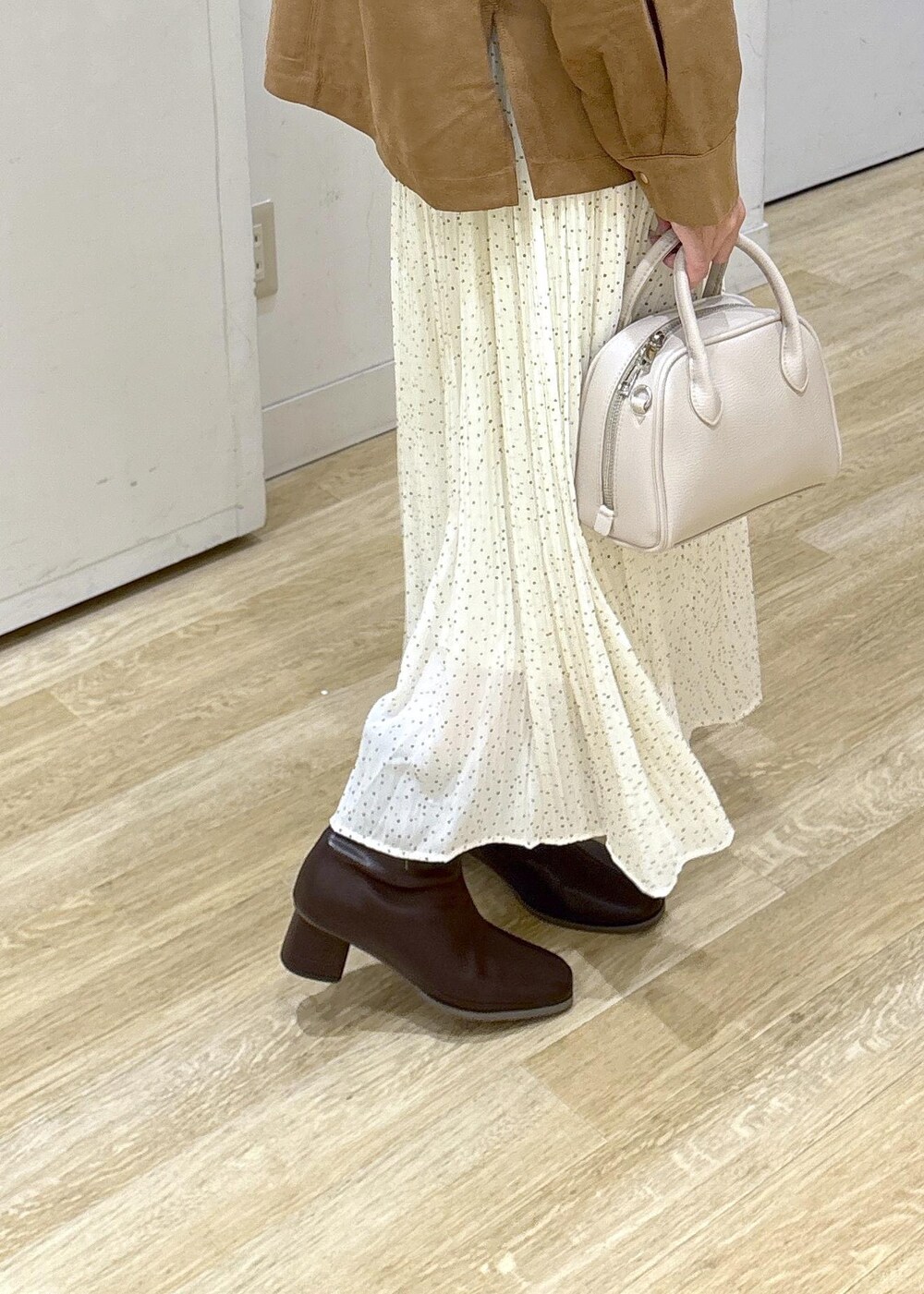 ホワイト系のスカート、ブラウン系のシャツ/ブラウス、ブラウン系のブーツを着用したレディースの秋コーディネートの7枚目の写真