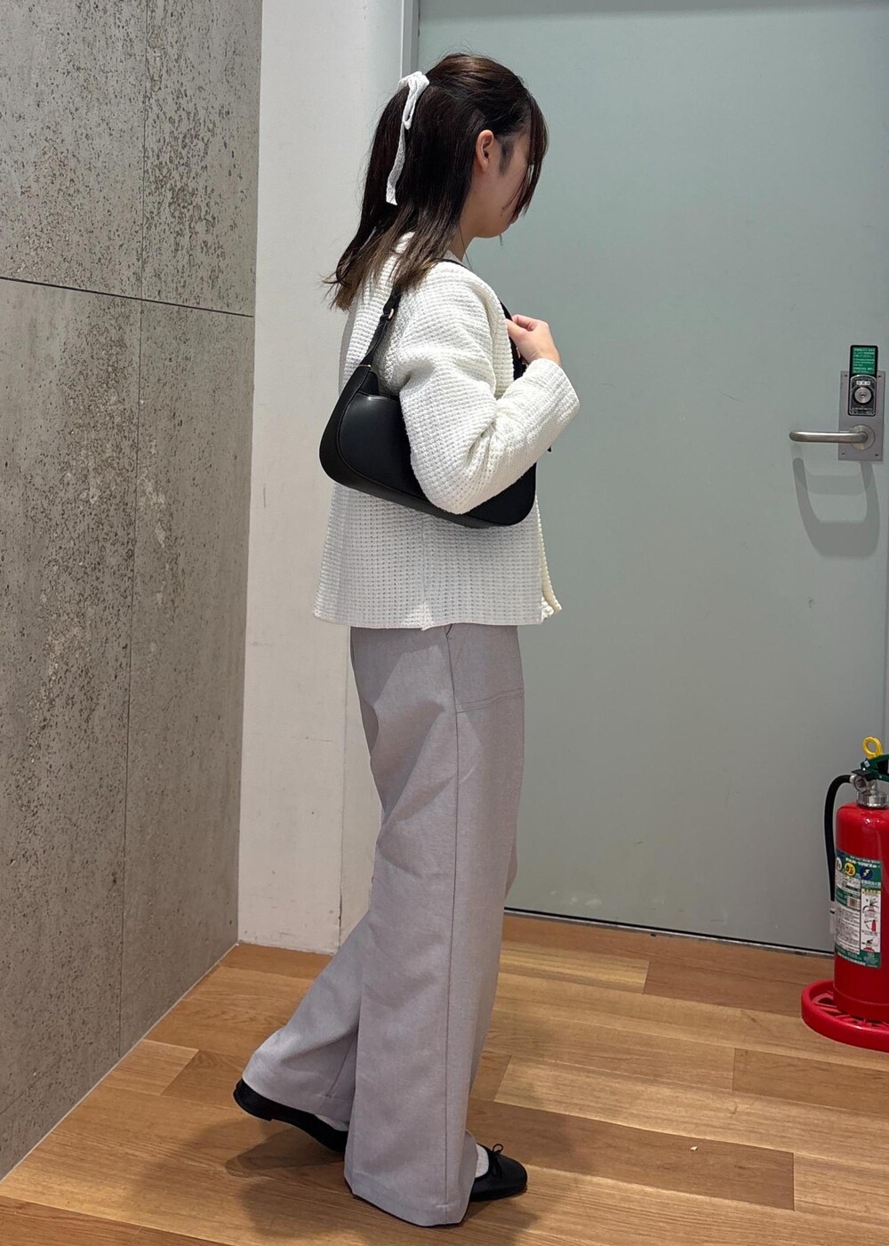 ブラック系のハンドバッグ、グレー系のその他パンツ、ホワイト系のカーディガン/ボレロを着用したレディースの春コーディネートの3枚目の写真