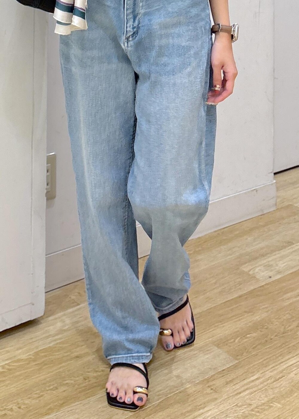 ブルー系のデニムパンツ、ブラック系のサンダル、ブラック系のショルダーバッグを着用したレディースの夏コーディネートの6枚目の写真