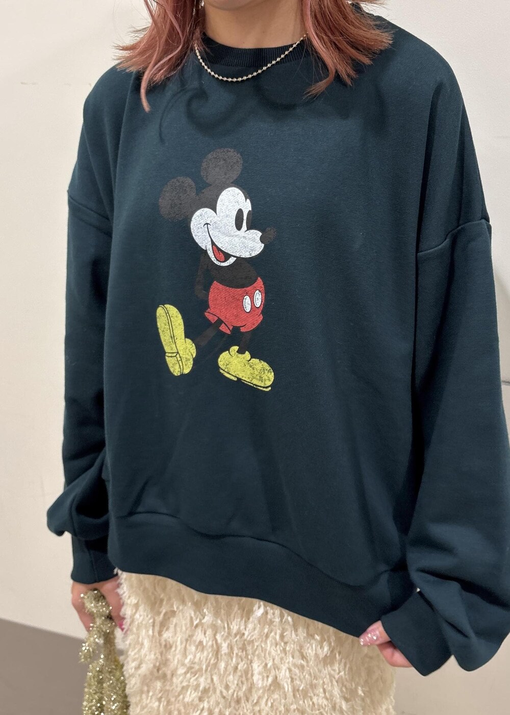 ホワイト系のスカート、ゴールド系のショルダーバッグ、グリーン系のスウェットを着用したレディースの冬コーディネートの5枚目の写真